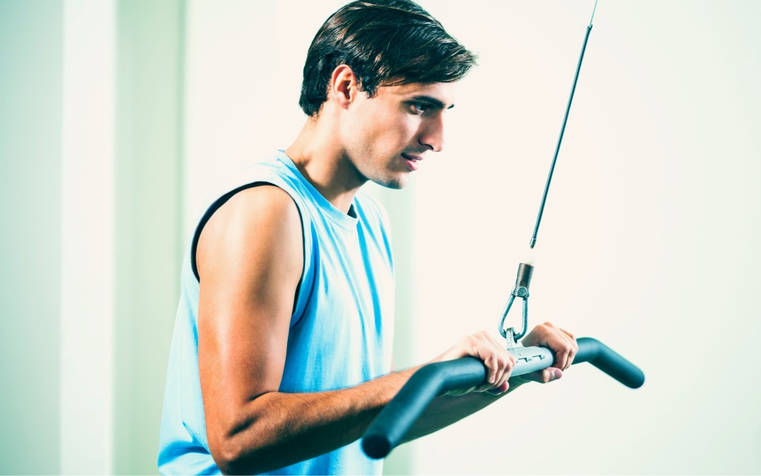 Man performs the straight bar tricep extension on a cable machine