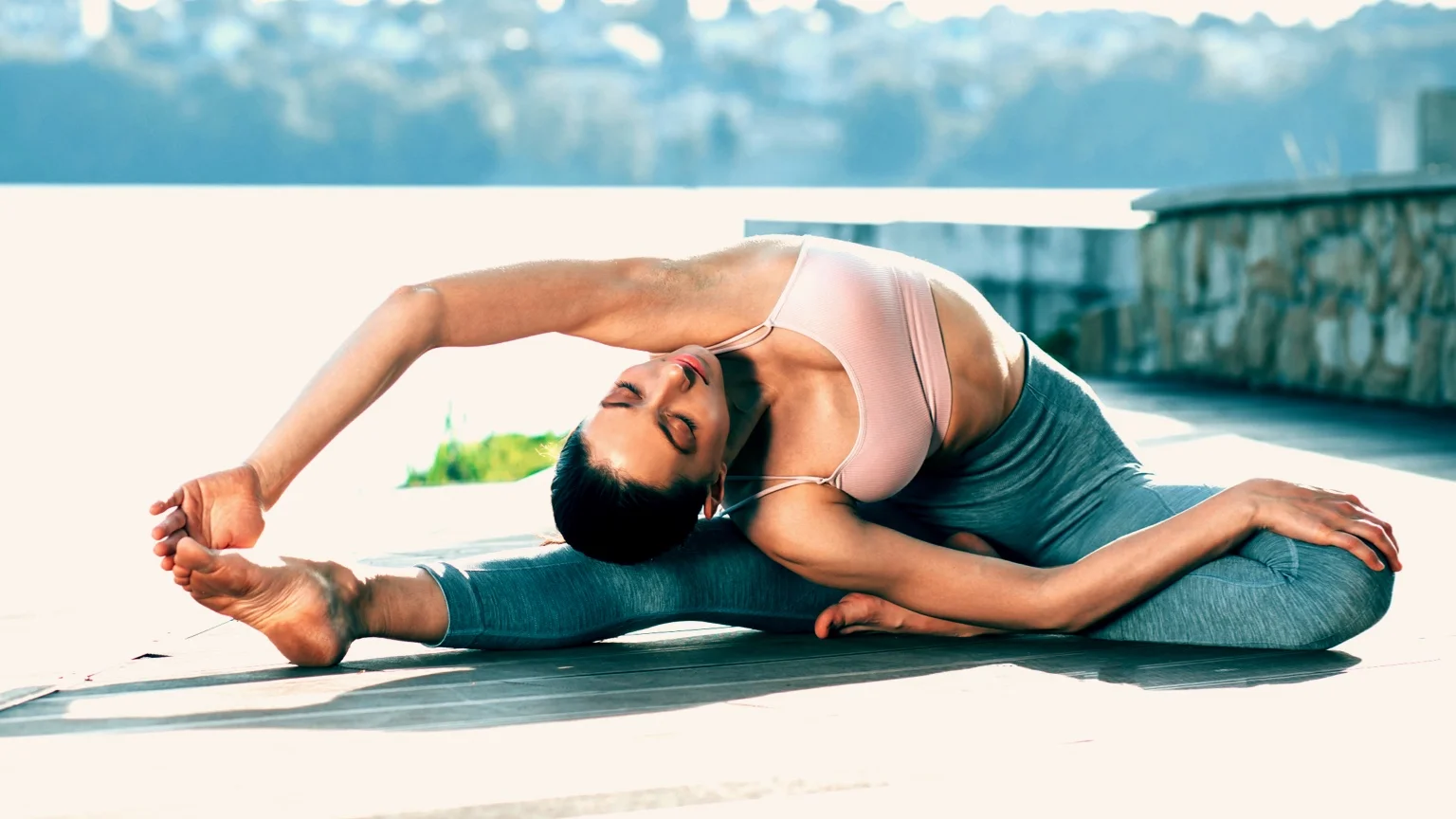 Woman does the Revolved Head to Knee Pose
