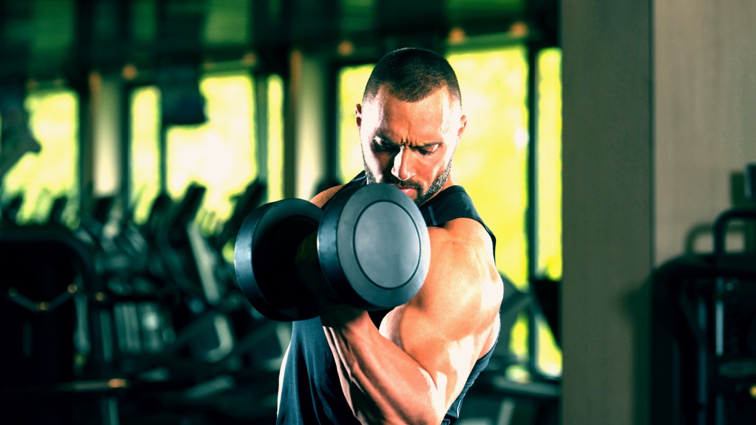 Man performs a bicep curl, an exercise in the ULPPL (upper lower push pull legs) split