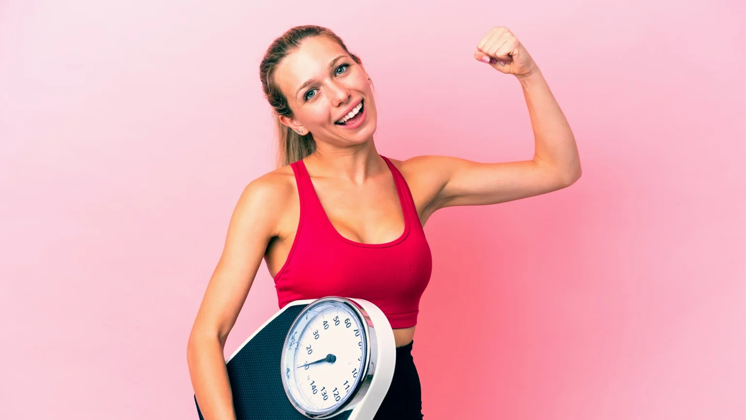 Woman holds a set of scales. The reverse BMI calculator outputs a target weight.