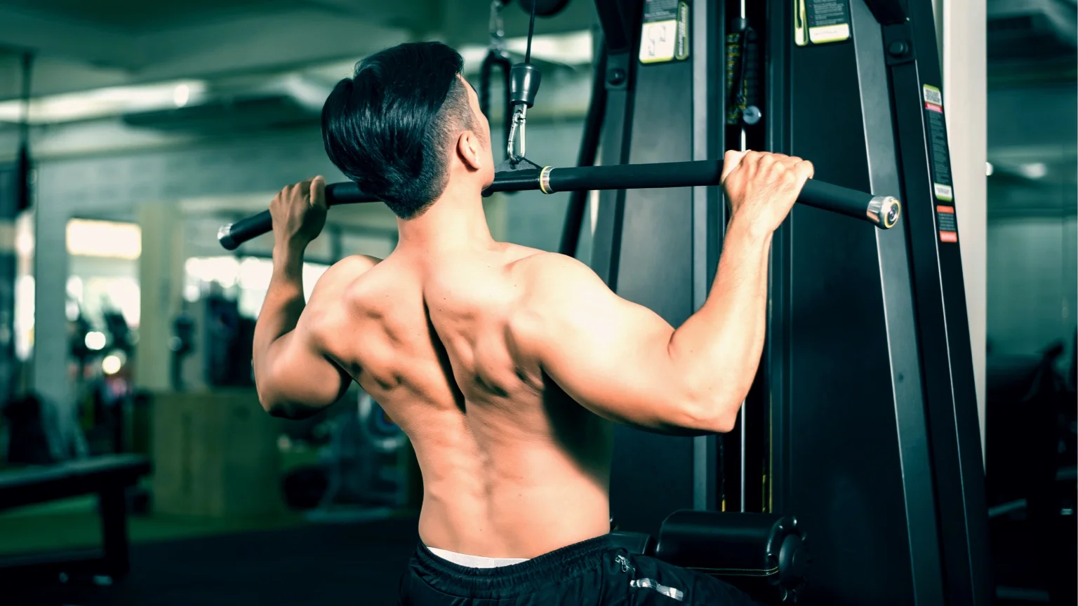 Man performs a lat pulldown, one of the exercises in the back day workout routine
