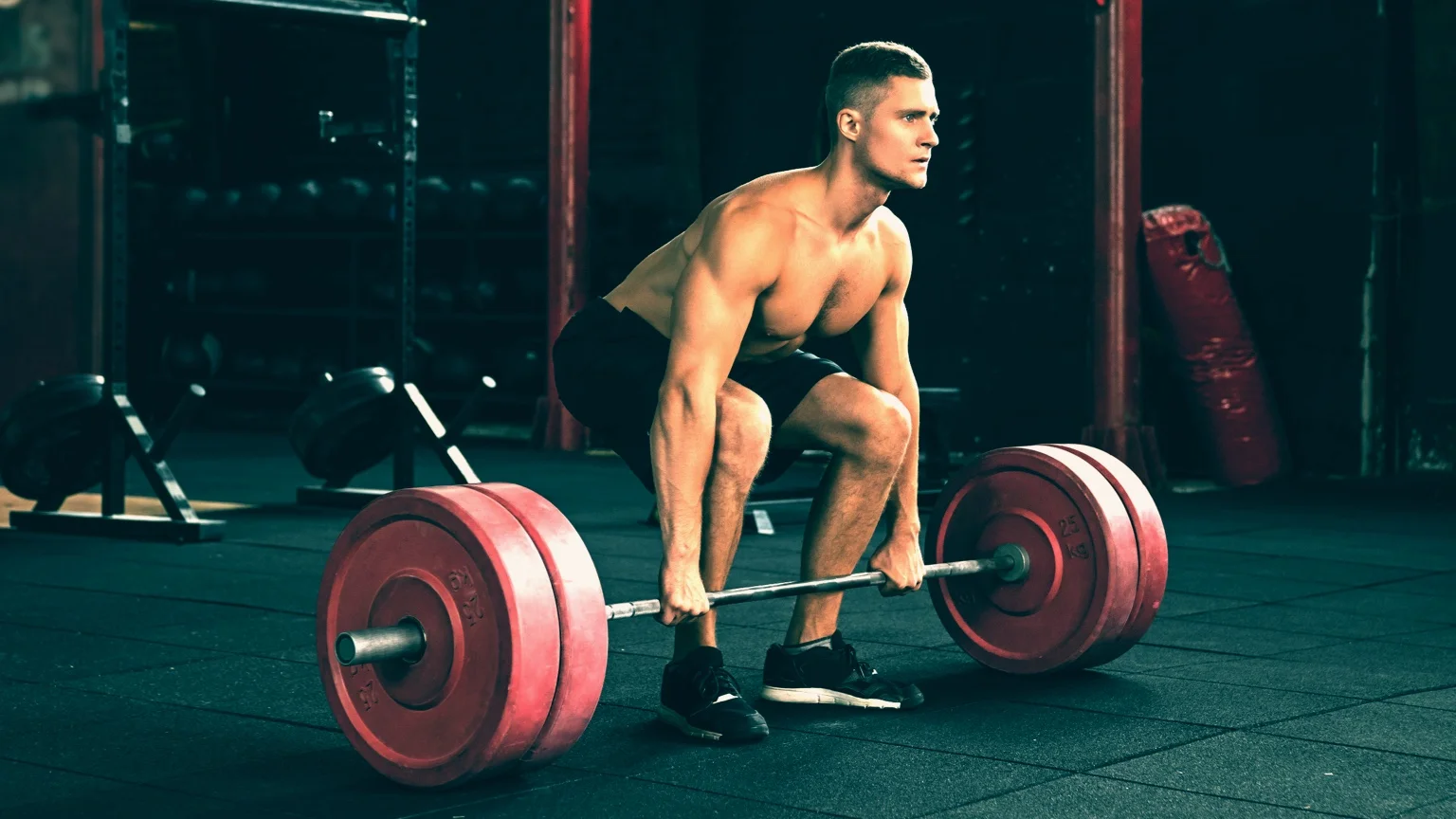photo - Man performs a deadlift, one of three powerlifting exercises