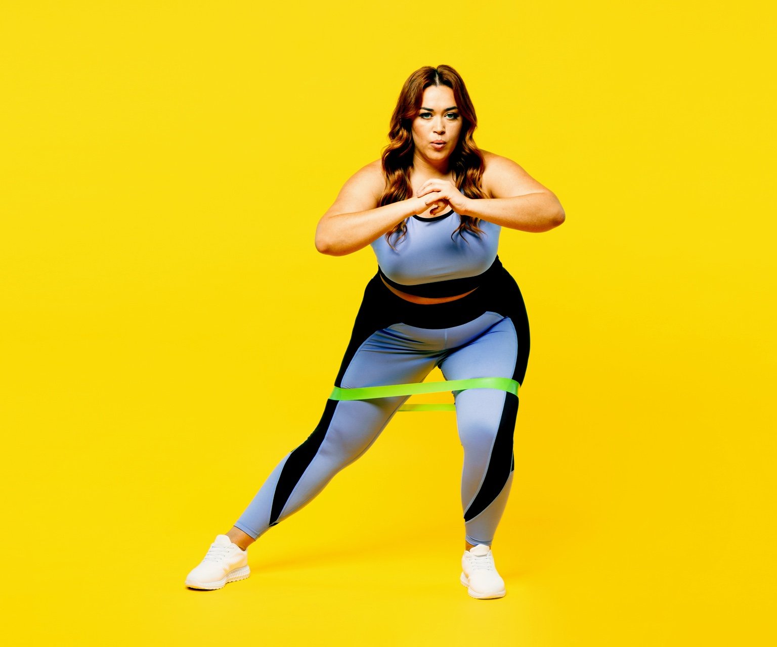 photo - A woman performs a bodyweight resistance band exercise