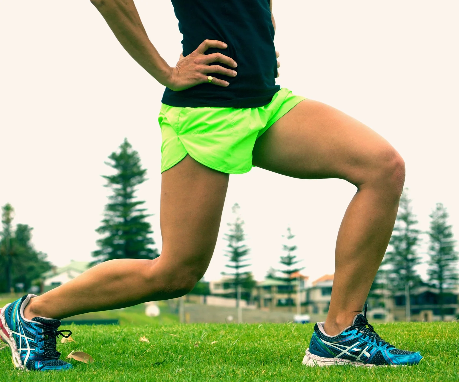 photo - Woman outdoors in a lunge position, showing her quads and hamstrings muscles.