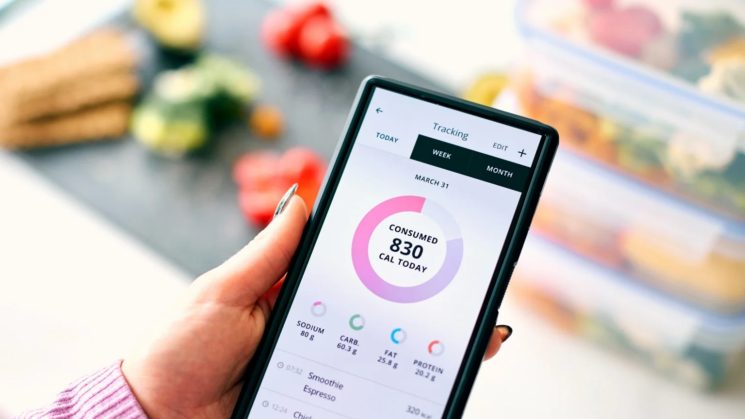 photo - A woman holds a phone, tracking her calories in a calorie tracking app