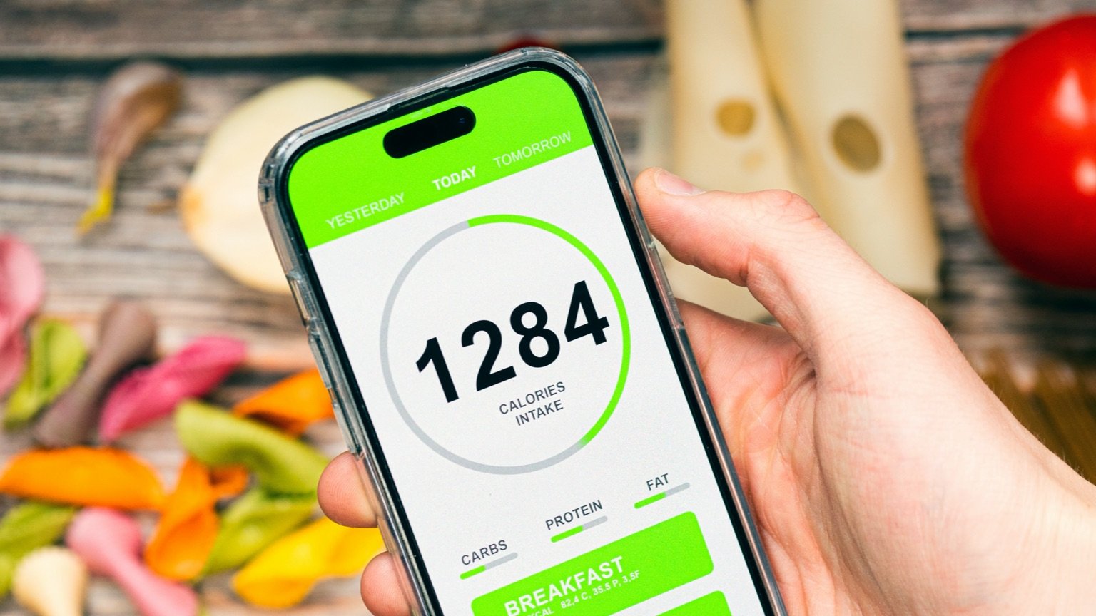 photo - Man tracks calories using an app. The zig zag calorie calculator provides a daily calorie goal for each day of the week.